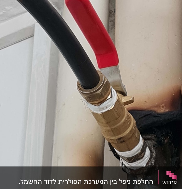 שסתום פליז עם ידית אדומה וצינור שחור